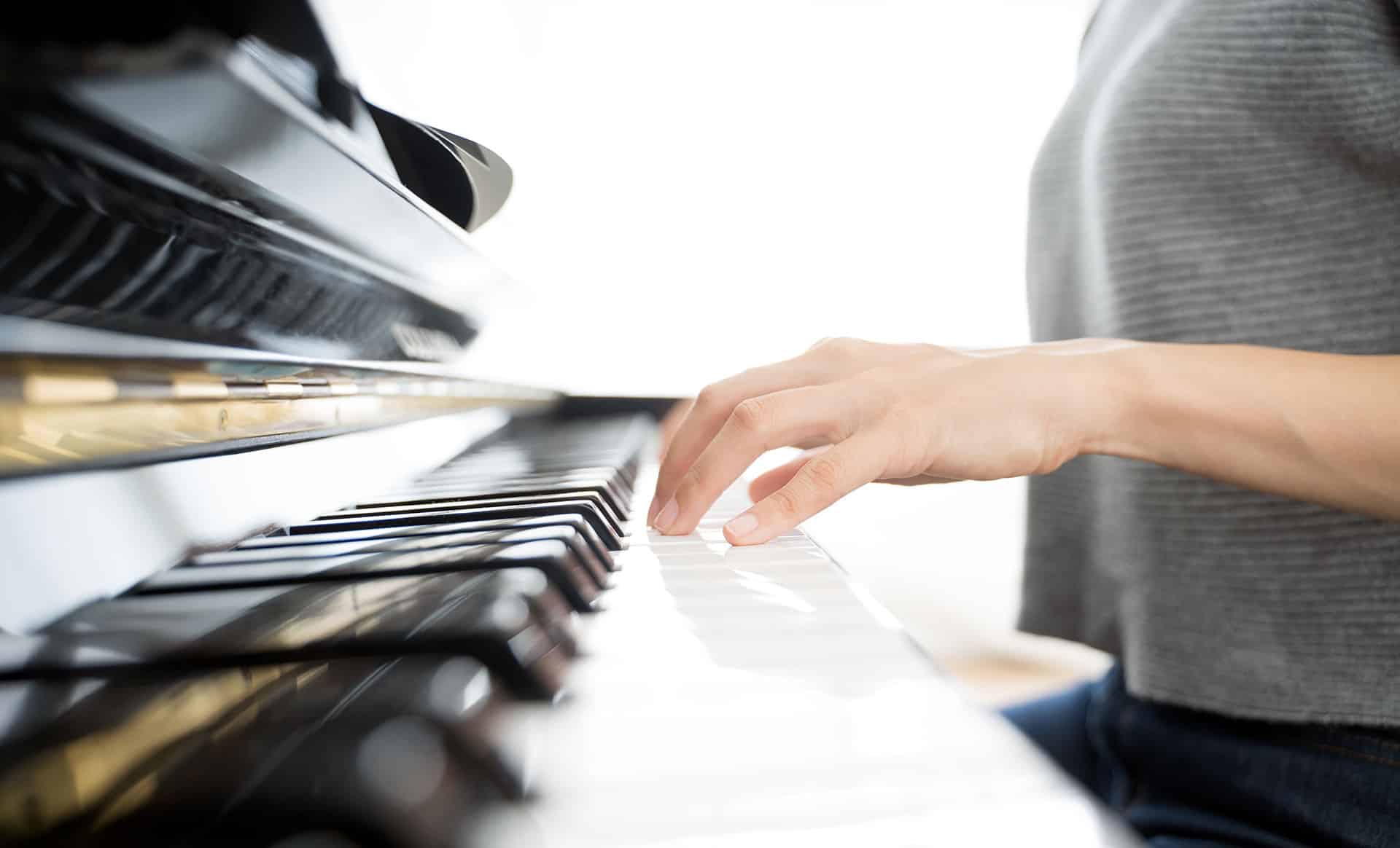 woman-playing-piano-hand-closeup Closeup of woman's hand on piano keyboard